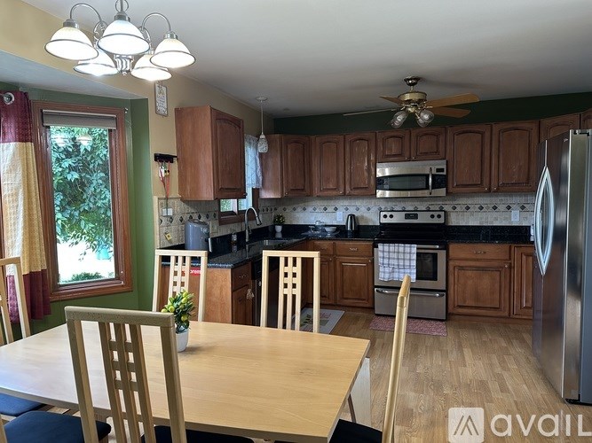 A kitchen with wooden cabinets and a table with chairs.