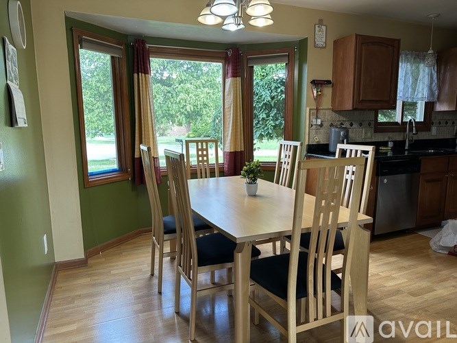 A dining room with a table and chairs.