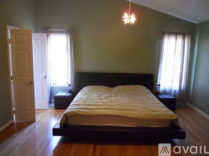 A bedroom with a large bed and a chandelier.