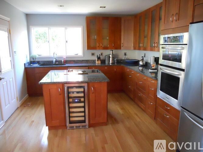 A kitchen with wooden cabinets and a central island with a wine rack.
