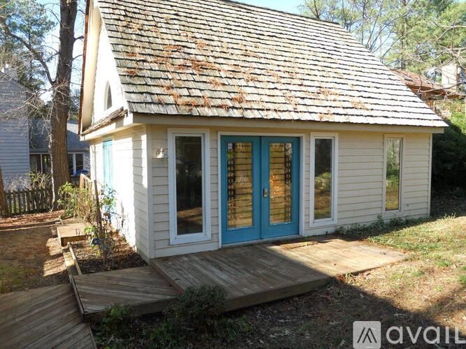 A small house with a blue door and windows is for sale.