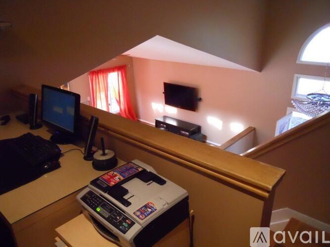 A room with a desk, computer, and printer.