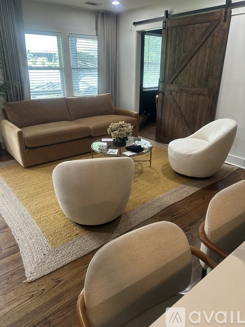 A living room with a brown sofa, a white chair, and a coffee table.