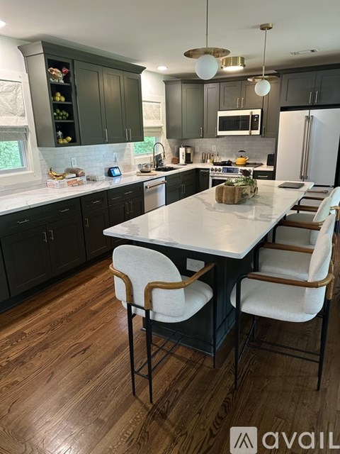 A kitchen with a table and chairs in the middle.