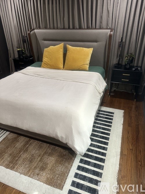 A bed with a white cover and two yellow pillows is in the image.