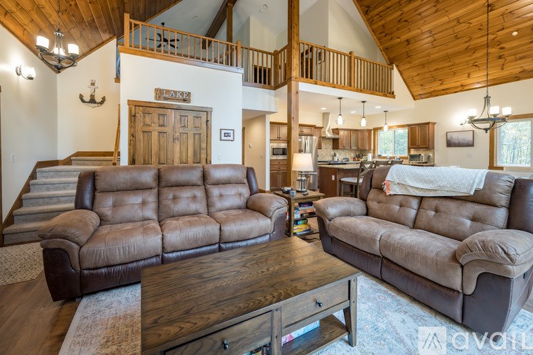 A living room with a large brown leather sofa and a wooden coffee table.