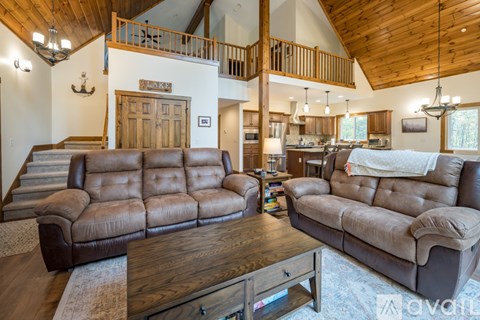 A living room with a large brown leather sofa and a wooden coffee table.