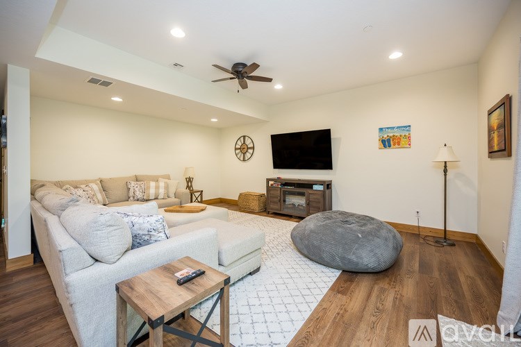 A living room with a white couch, a wooden coffee table, and a ceiling fan.