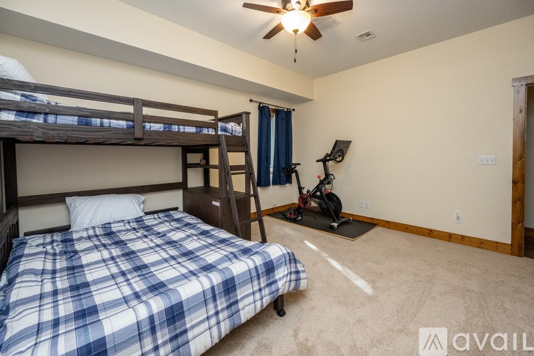 A room with a bed, a chair, and a fan.