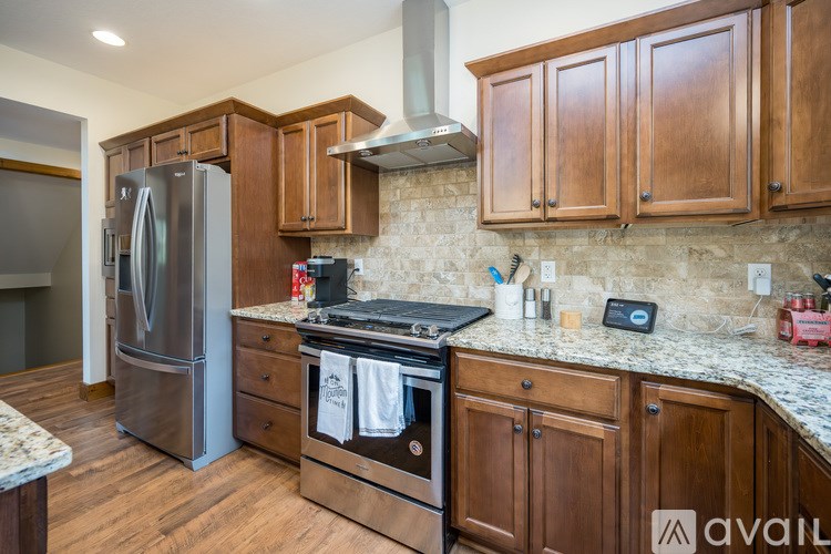 A kitchen with wooden cabinets and a stainless steel refrigerator.