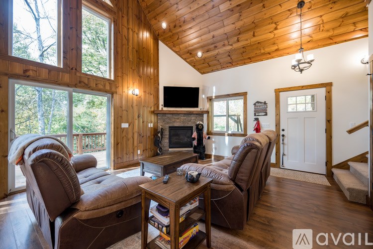 A living room with a brown couch and a wooden ceiling.