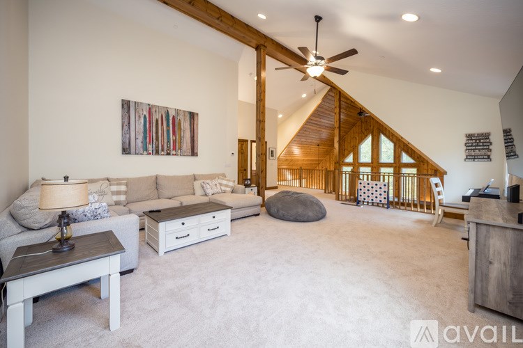 A living room with a white couch, a coffee table, and a painting on the wall.