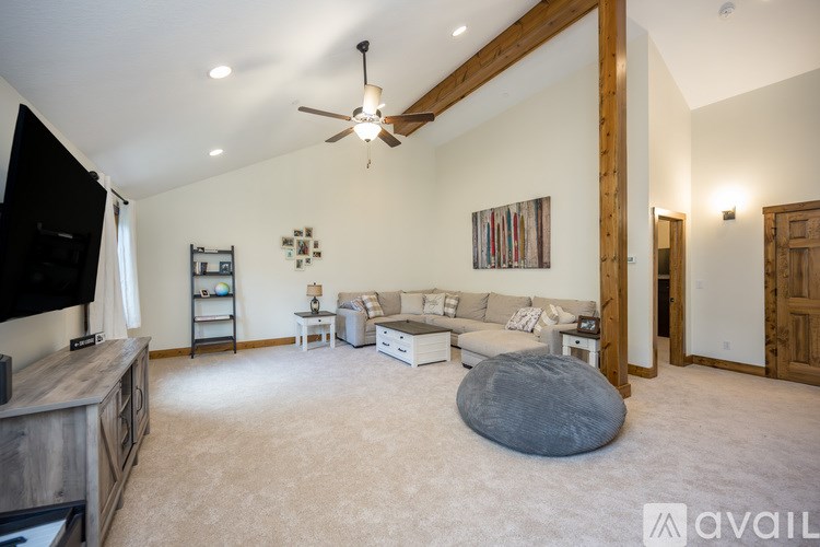A spacious living room with a grey bean bag in the middle.
