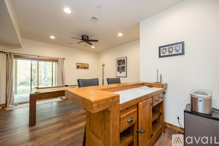 A kitchen with a wooden island and a fan on the ceiling.
