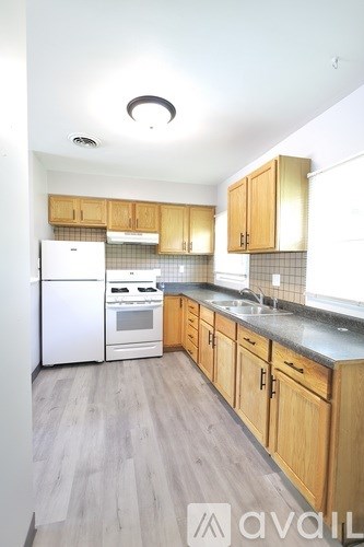 A kitchen with wooden cabinets and a white refrigerator.