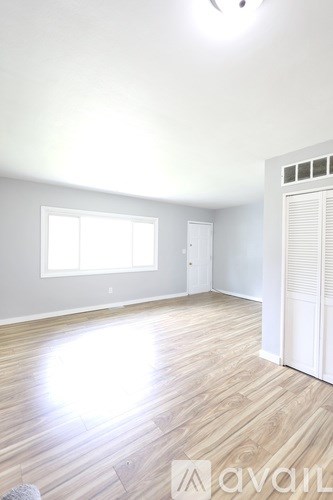 A room with wooden flooring and a window.