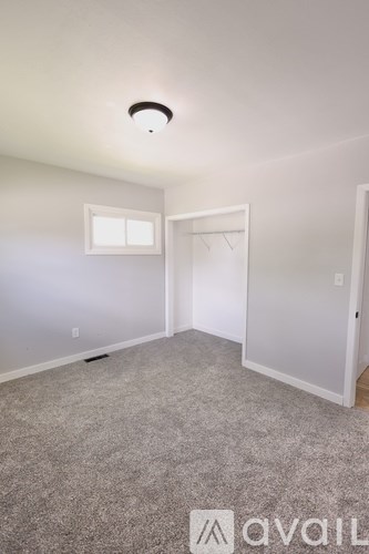 A room with a carpeted floor and a window.