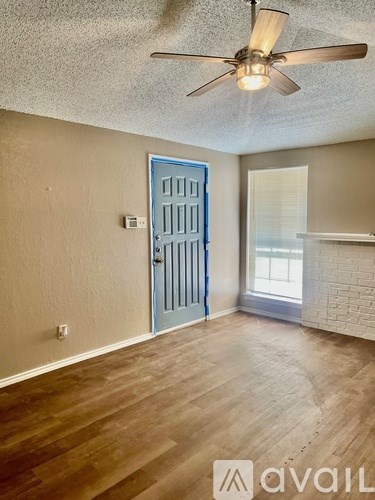 A room with a blue door and a ceiling fan.