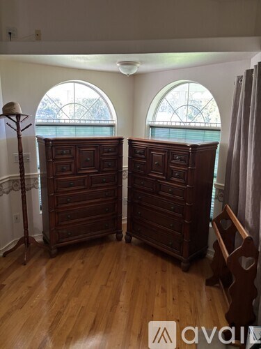 A room with two dressers and a window.