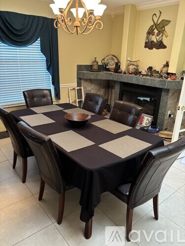 A dining table with a checkered tablecloth and chairs.