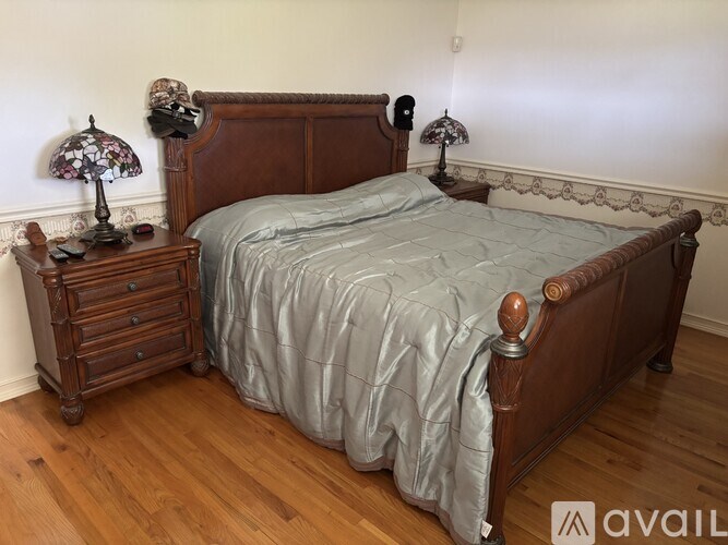 A bedroom with a bed, nightstand, and lamp.