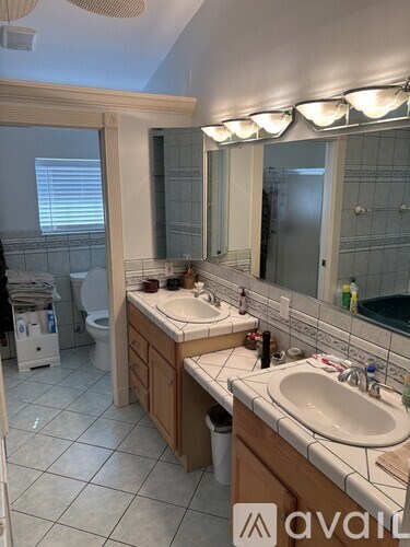 A bathroom with a sink, mirror, and toilet.