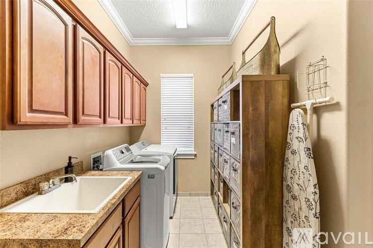A kitchen with brown cabinets and a white sink.