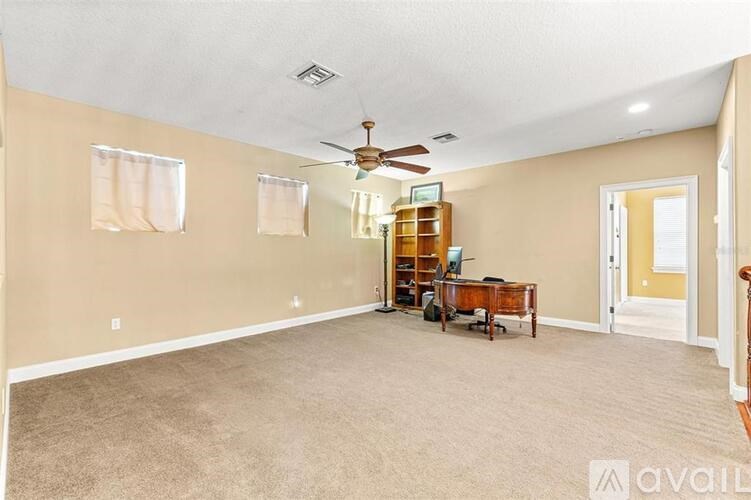 A living room with a ceiling fan and a piano.