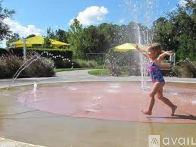 A child is playing with a water hose in a fountain.