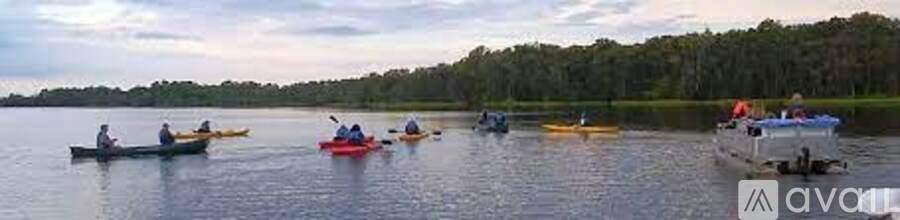 A group of people are kayaking on a calm body of water.