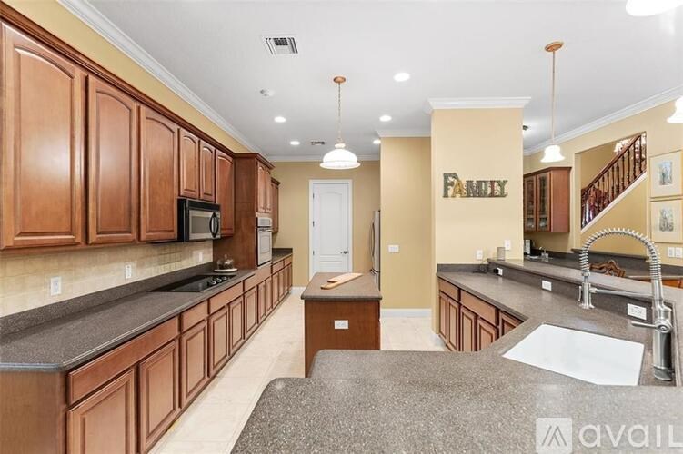 A kitchen with brown cabinets and a granite countertop.