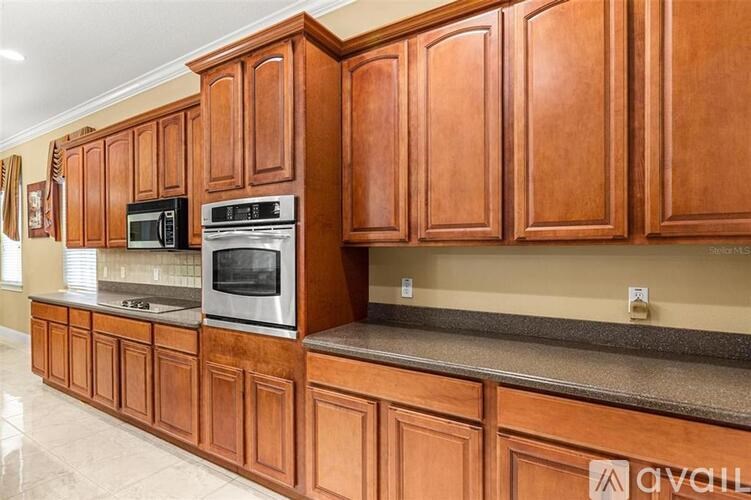 A kitchen with wooden cabinets and a granite countertop.