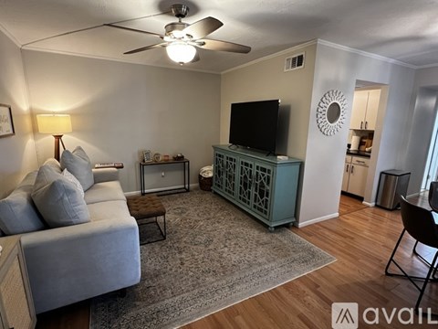 A living room with a grey couch and a green cabinet.