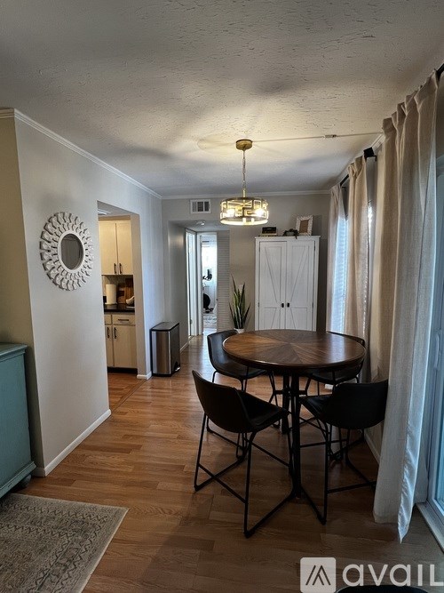 A dining room with a round table and chairs.