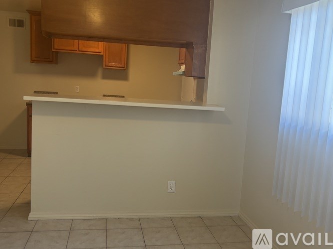 A white reception desk in a room with a window on the right.