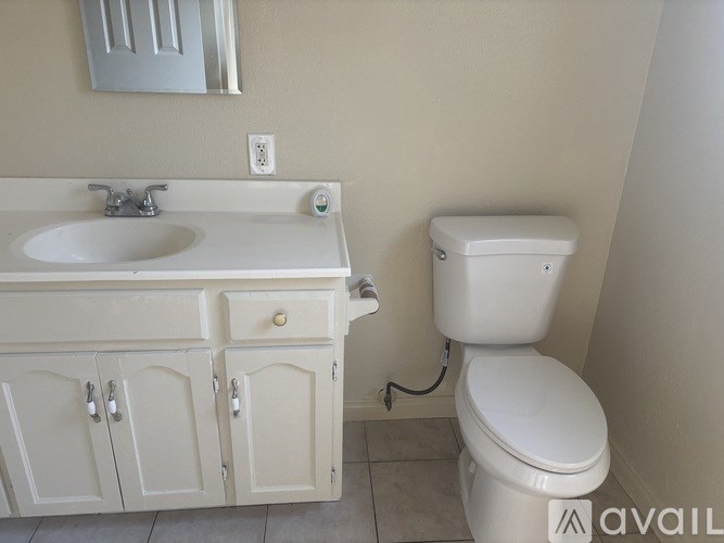 A white toilet is next to a sink in a bathroom.