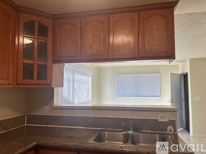 A kitchen with wooden cabinets and a granite countertop.