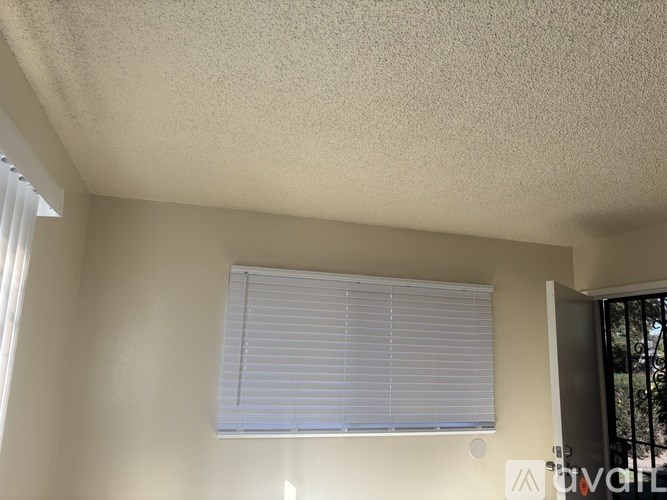 A white window with blinds is on a wall.