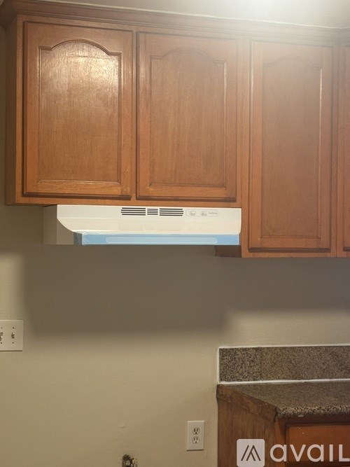 A kitchen with wooden cabinets and a white oven.