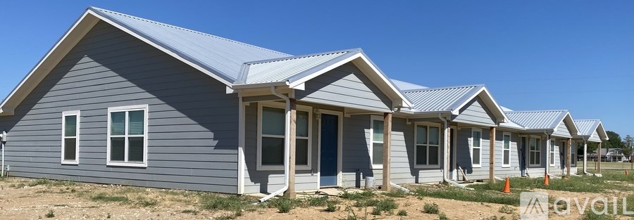 A row of houses with grey siding and white trim.