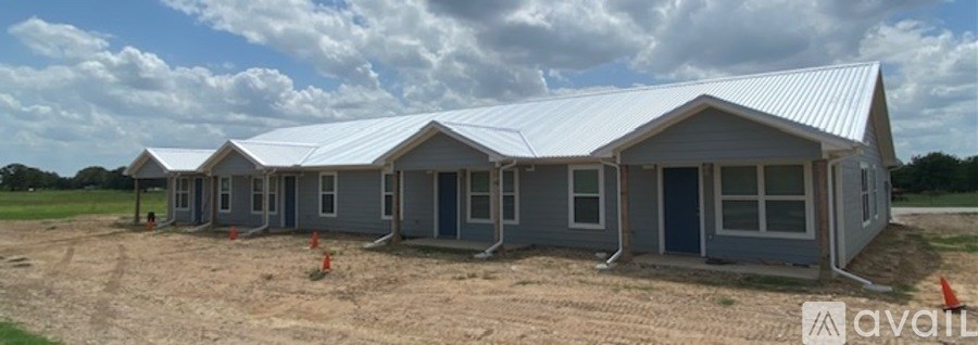A row of prefabricated houses are lined up in a field.