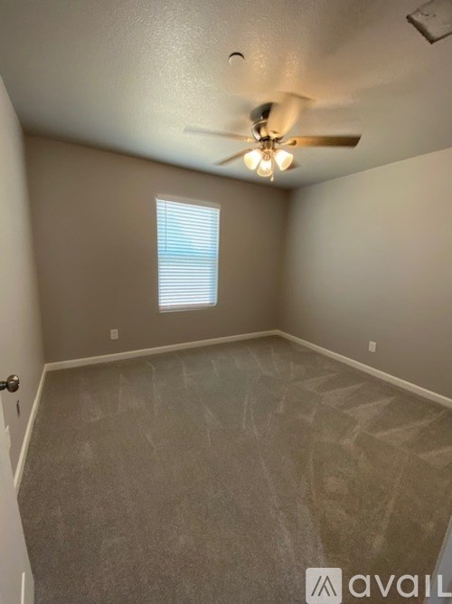 A room with a ceiling fan and a window.