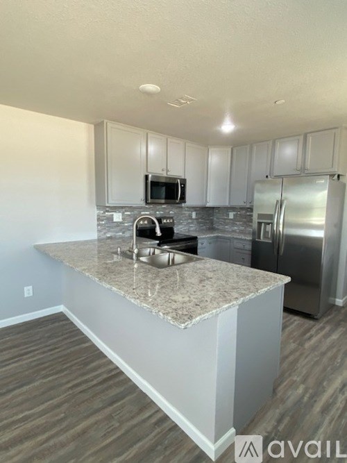 A kitchen with granite countertops and stainless steel appliances.