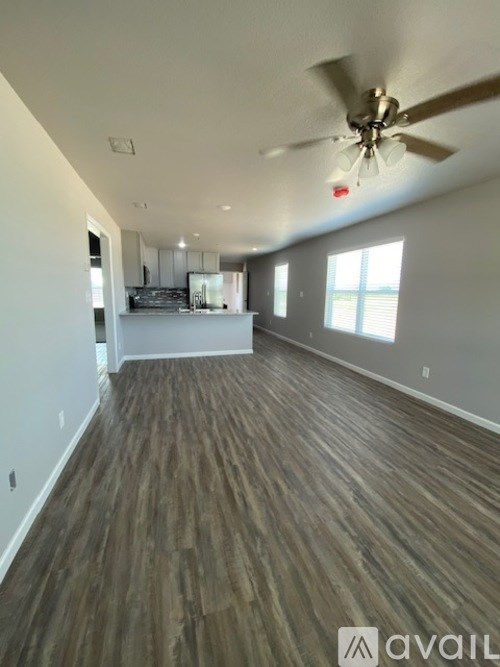 A room with wooden flooring and a ceiling fan.