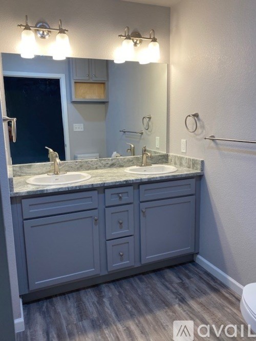 A bathroom with a granite countertop and a large mirror.