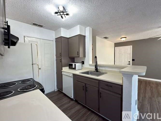 A kitchen with a white countertop and brown cabinets.