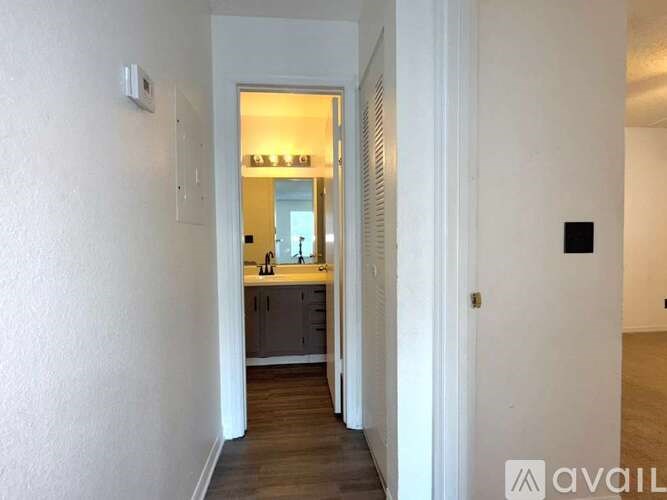 A hallway with a kitchen visible in the distance.