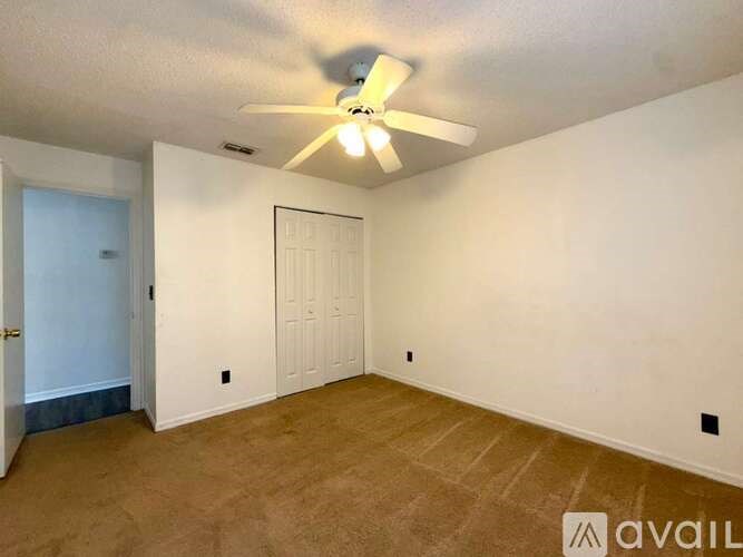 A room with a ceiling fan and two doors.