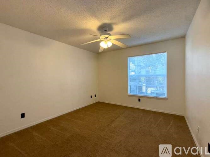 A room with a ceiling fan and a window.