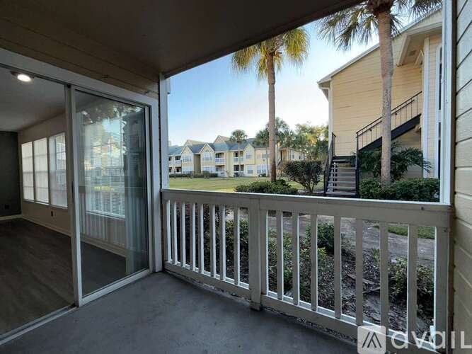 A balcony with a glass door leading to a residential area.
